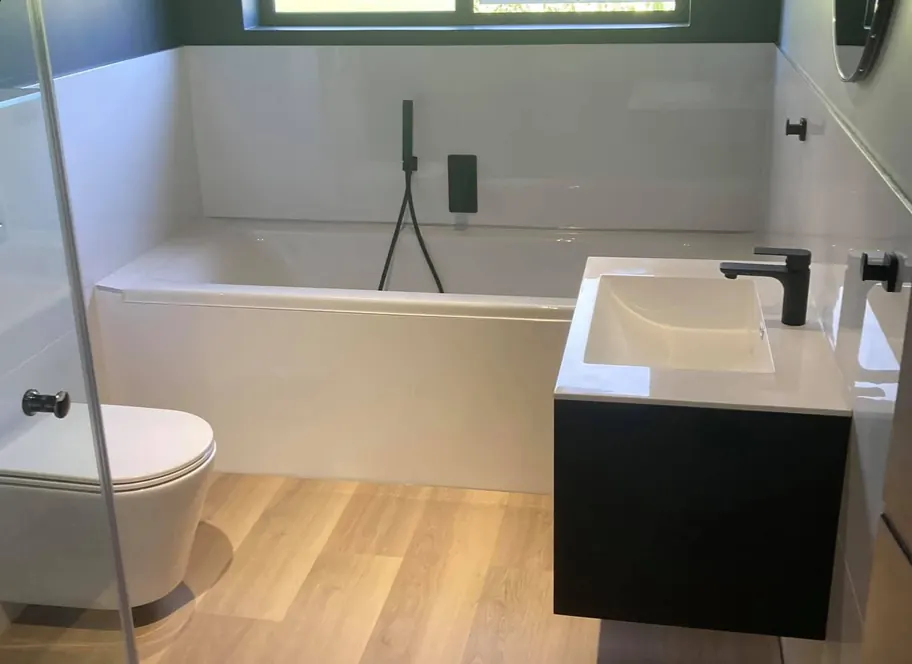 A bath and floating vanity in a renovated home bathroom