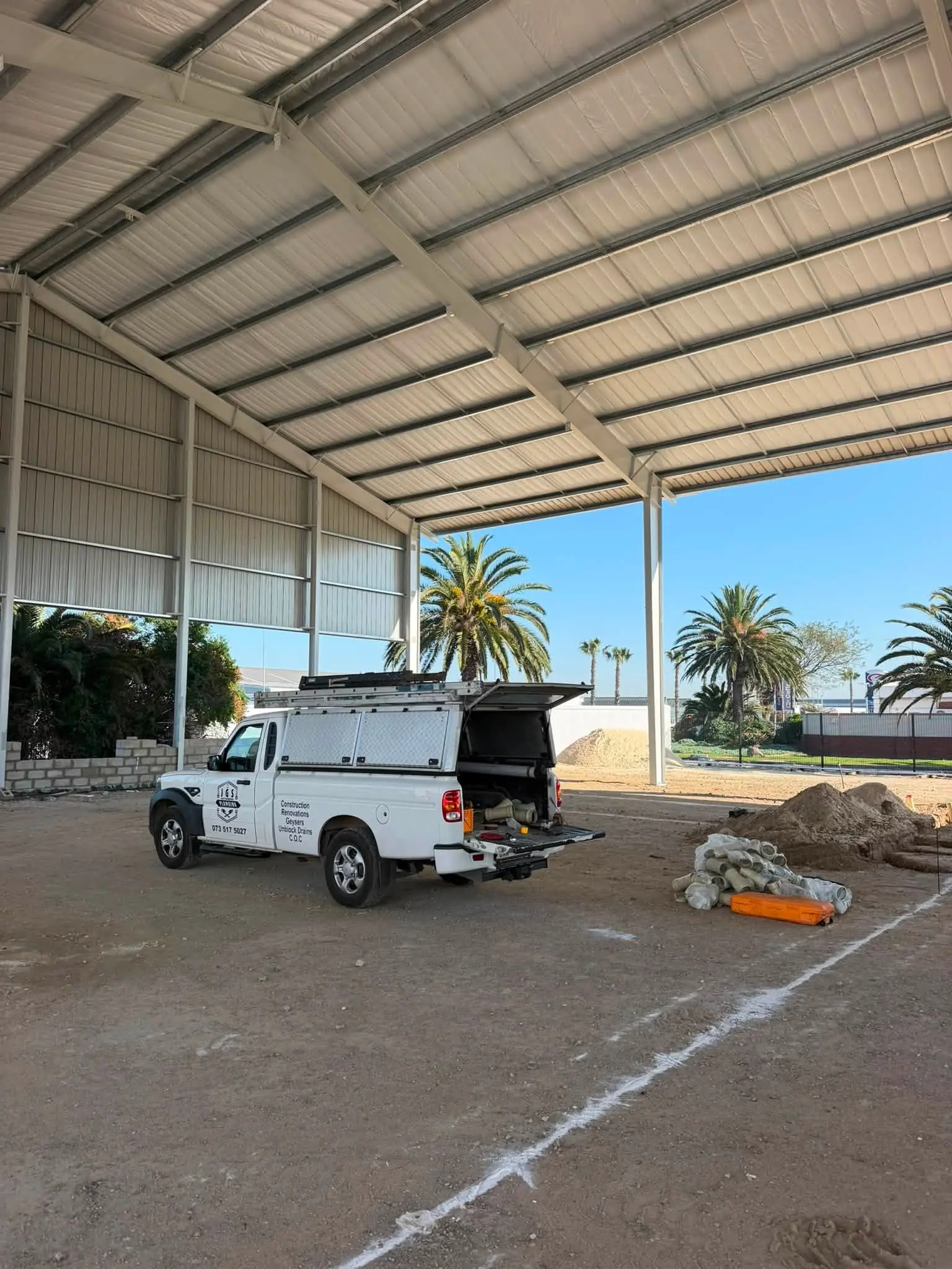 A JGS Plumbing bakkie on a commercial construction site